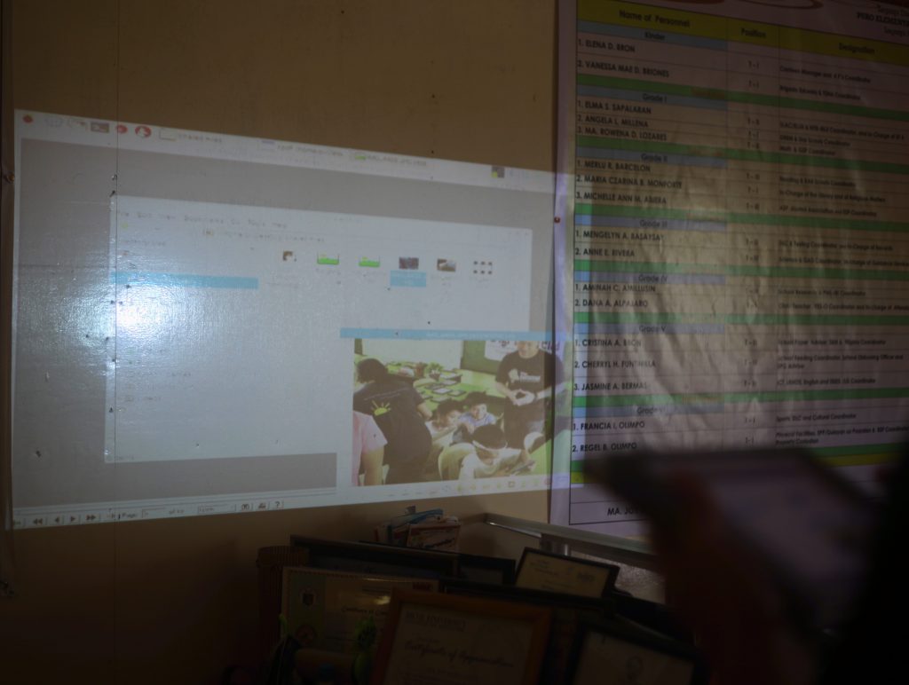 Portable projector screening learning materials on screen