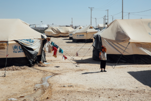 A child standing alone in a refugee camp