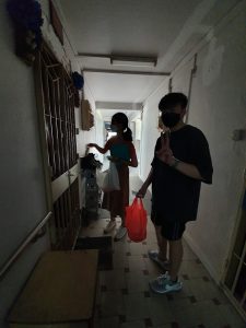 The intern distributing food at one of the units at Ang Mo Kio
